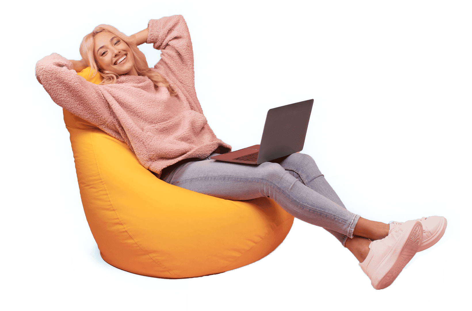 Lächelnde Frau sitzt entspannt auf einem gelben Sitzsack mit Laptop vor einem blauen Hintergrund