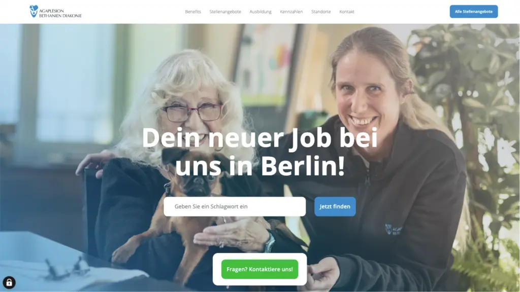 Zwei Frauen, eine ältere mit Hund und eine jüngere, lächeln in einem hellen Raum.