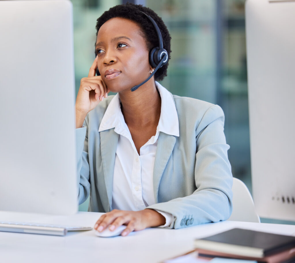 Frau mit Headset arbeitet an einem Computer im Büro