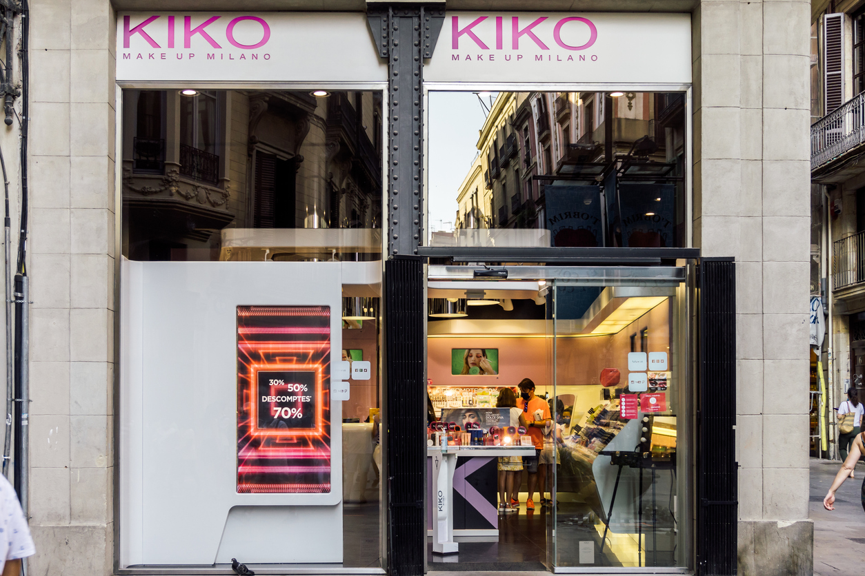 Auf dem Bild sind das Logo und Fassade einer Kiko Milano Filiale zu sehen. Kiko Makeup Milano ist ein Unternehmen, das sich der Herstellung und dem anschließenden Verkauf von Make-up und Kosmetik widmet.