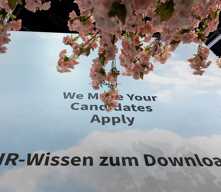 Das Foto zeigt den Schriftzug "We Make Your Candidates Apply" auf einer großen Wand