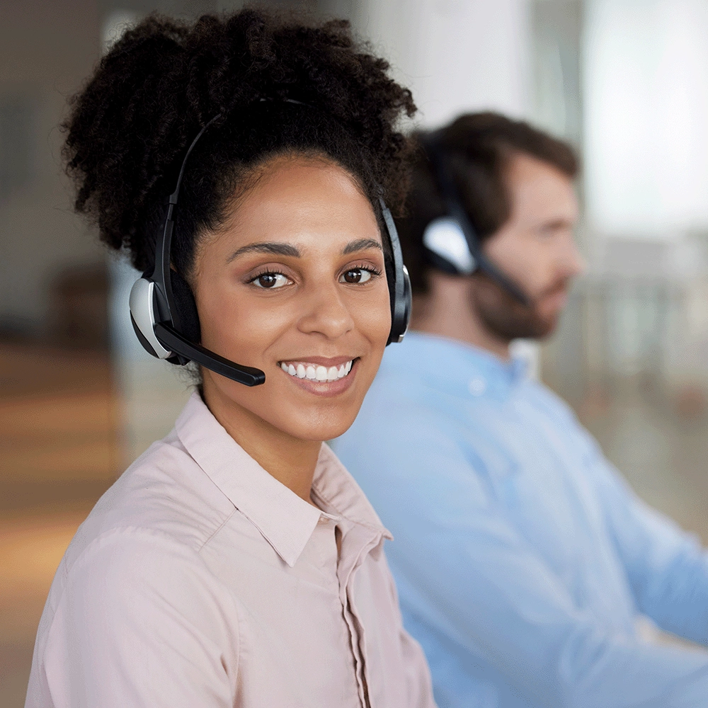 The photo shows a person wearing a headset and smiling at the camera