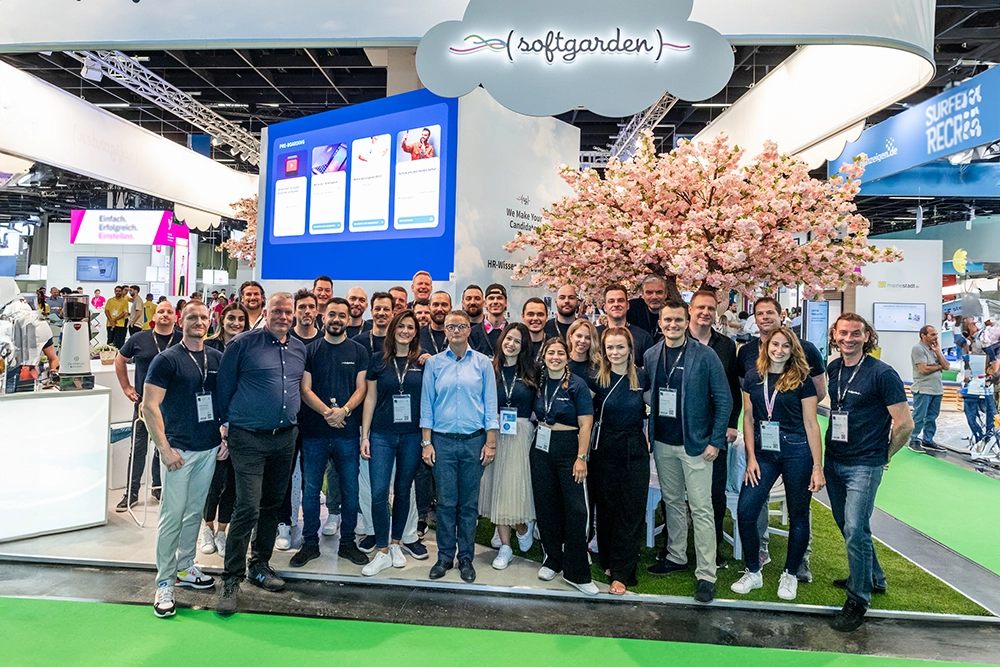 Ein Gruppenbild der etwa 30 Teammitglieder vor dem softgarden-Messestand